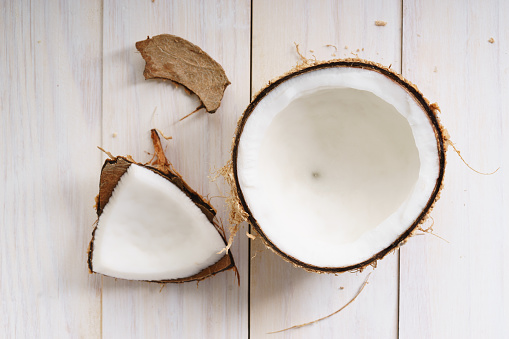 coconut with shell on white wooden background