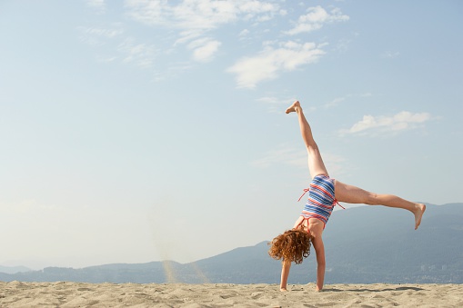 Girl doing a cartwheel on the beach