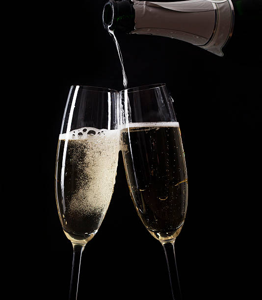 istock Champagne pouring in two glasses from a bottle 521023767