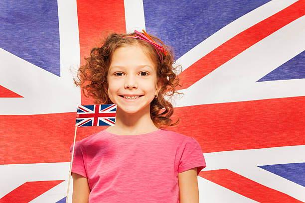 divertido chica con poco bandera británica en contra banner - british empire flag global uk fotografías e imágenes de stock