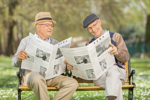 Senior man showing photographs to his son