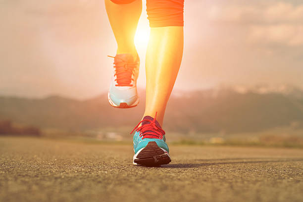 istock Runner athlete feet running on road under sunlight. 521040296
