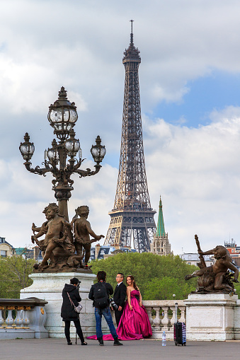 Paris, France - April 14, 2014: Asian couple does a wedding photo shoot at the pont Alexandre III with the Eiffel tower in the background in Paris, France, on April 14, 2014
