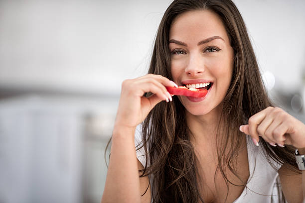 Brunette woman eating red pepper
