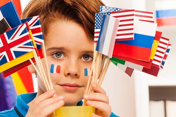 French boy with flag on cheeks hide behind banners Close up picture of French boy with flags on cheeks hiding behind flags french flag stock pictures, royalty-free photos & images