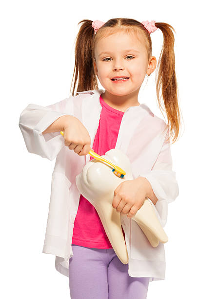 маленькая девочка, держа зубная щетка модели и желтый - dentist office audio стоковые фото и изображения
