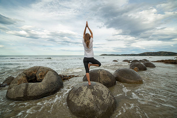 istock Yoga on spheric boulder by the sea 521047714