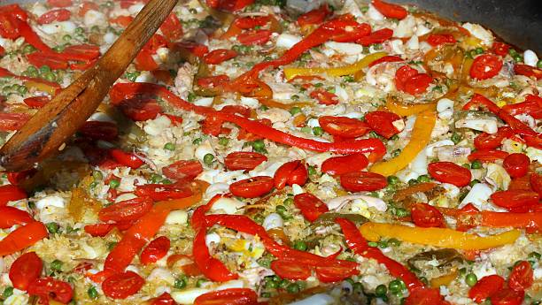 istock cooking Spanish paella with wooden spoon 521049709