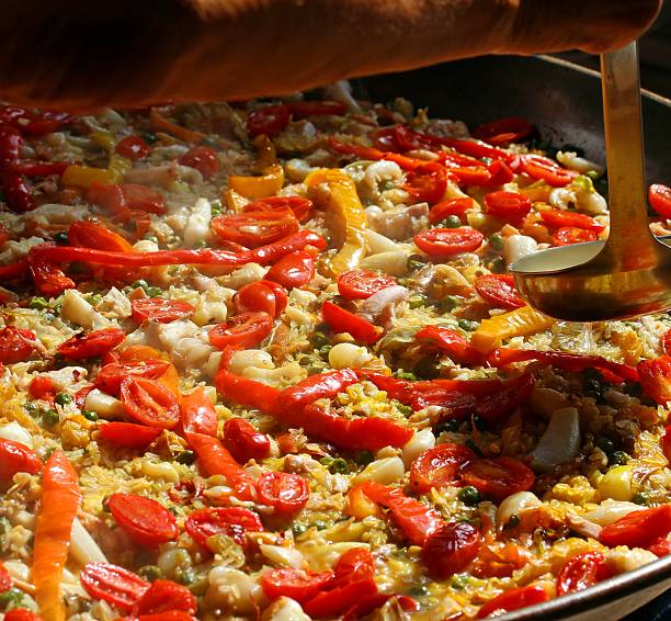 istock cooking Spanish paella with Chef's spoon 521049713