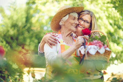 Senior woman and her adult daughter gardening on a nice summer day