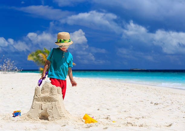 istock little boy building sand castle on beach 521070027