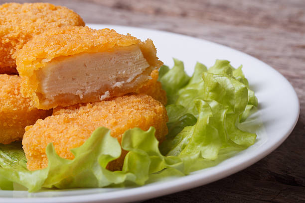 istock chicken nuggets and lettuce on a white plate 521073959