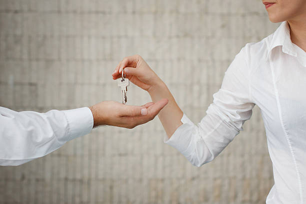 istock Man and woman hand passing keys 521074159