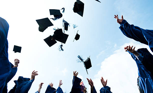 throwing graduation hats Group of graduate students throwing graduation hats to the sky. graduation throwing cap stock pictures, royalty-free photos & images