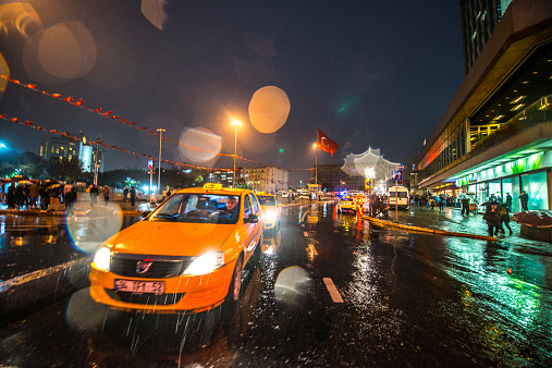 Istanbul, Turkey - October 31, 2014: Taxi moving on rainy Taksim Square, Istanbul
