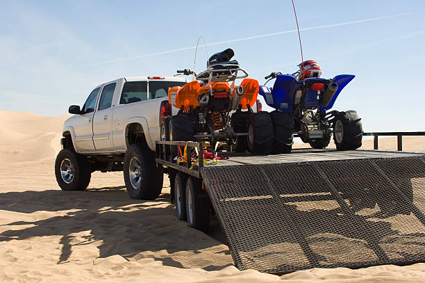 ATVs on Trailer Behind Pickup Truck