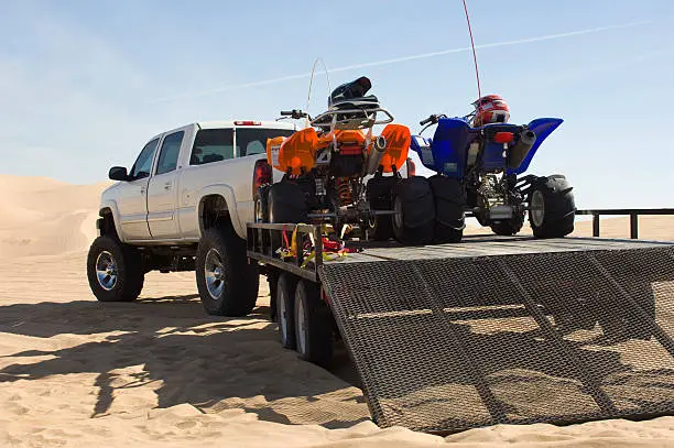 ATVs on Trailer Behind Pickup Truck