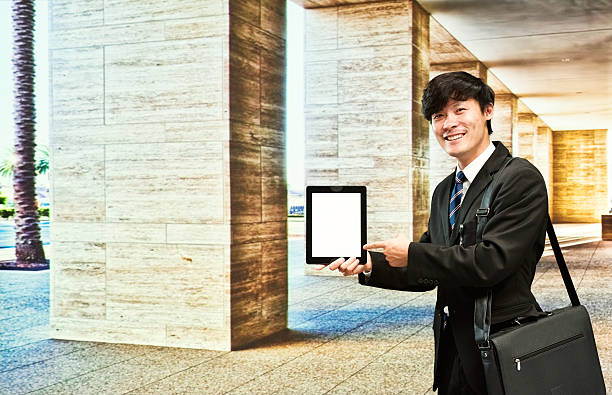 istock Smiling businessman pointing at tablet 521076176
