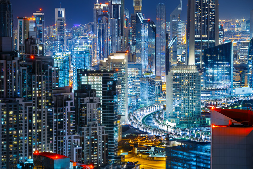 Fantastic rooftop view of city architecture by night. Business bay, Dubai, United Arab Emirates. Nightlife background.