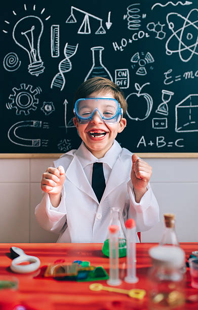 istock Happy kid with glasses laughing behind of experiments table 521078952