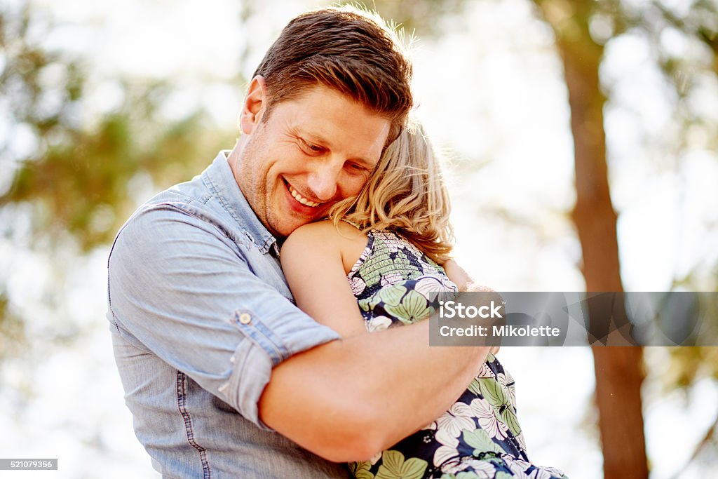Safe in daddy’s arms Shot of a happy young father and daughter spending time together outdoors Adult Stock Photo