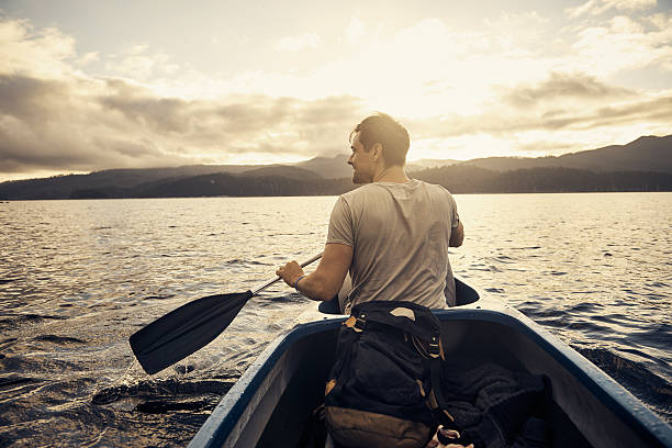natura ha un sacco di bellezza per offrire - men sitting canoe canoeing foto e immagini stock