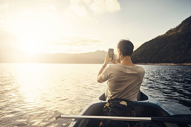 ricordi realizzati sul lago - men sitting canoe canoeing foto e immagini stock