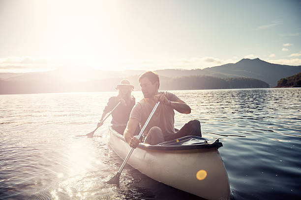 per un rilassante giro in barca - men sitting canoe canoeing foto e immagini stock