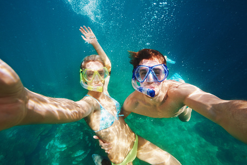 Shot of a young couple snorkelling in crystal clear water