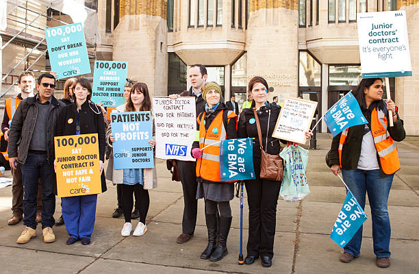 The Fourth Junior Doctors' Strike. London, United Kingdom - April 6, 2016:  Singers, chanters, nurses, teachers, patients and lots of junior doctors turned up for the fourth Junior Doctors' strike rally. strike protest action stock pictures, royalty-free photos & images