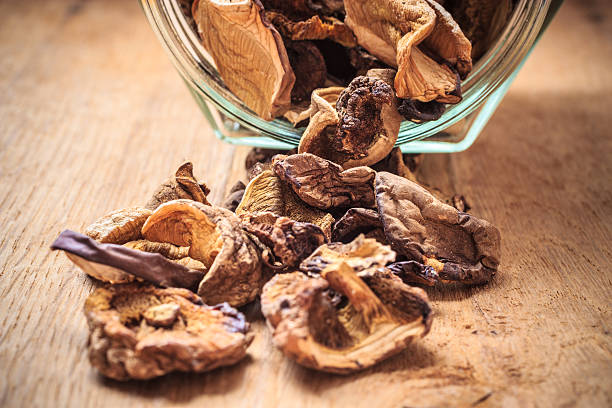 istock Dry mushrooms in jar on wooden table. 521086166