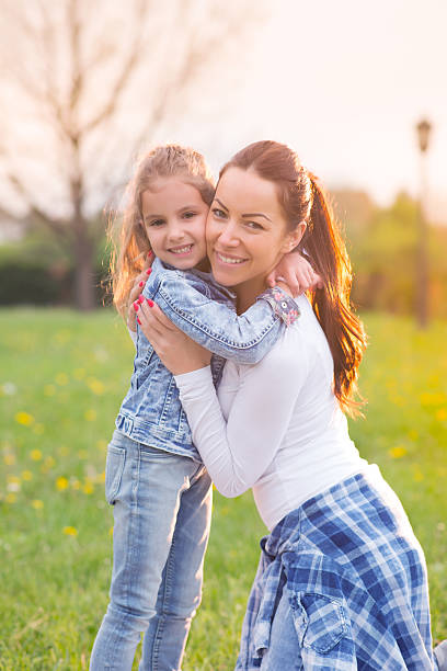 istock Mother and her daughter sitting on the grass 521087092