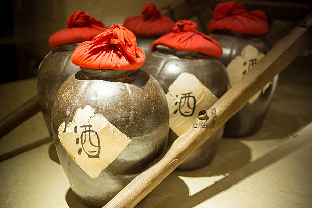 Row of ancient chinese jugs inside with the chinese character for alcohol written on the outside