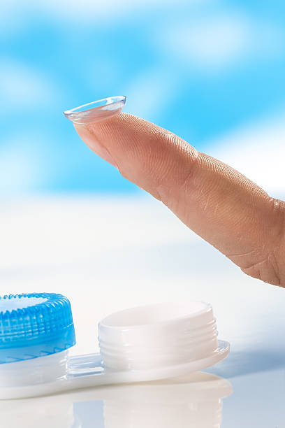 istock Contact lens on finger tip  blue background 521087626