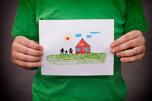 istock Child holds a drawn house with family 521088242