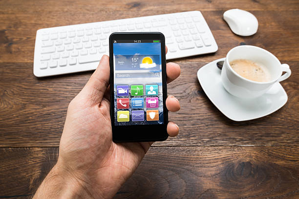 istock Person Holding Mobile Phone With Tea Cup On Desk 521089136