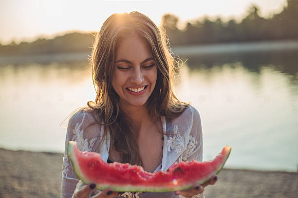 istock Girl eating watermelon and smiling. Sunset 521090302