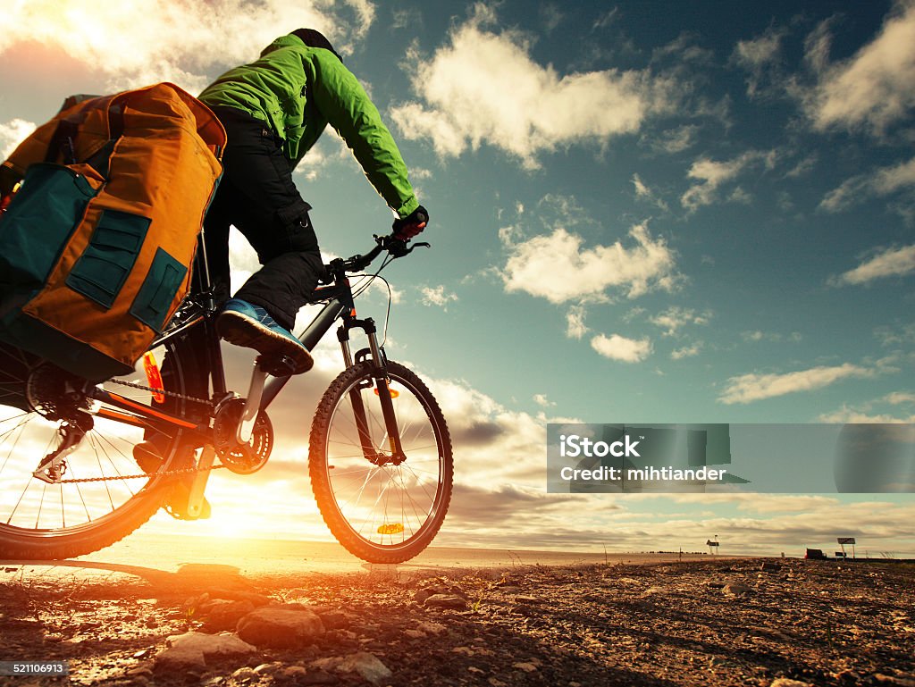 Tourist Bicycle tourist with loaded bike riding on an empty road Activity Stock Photo