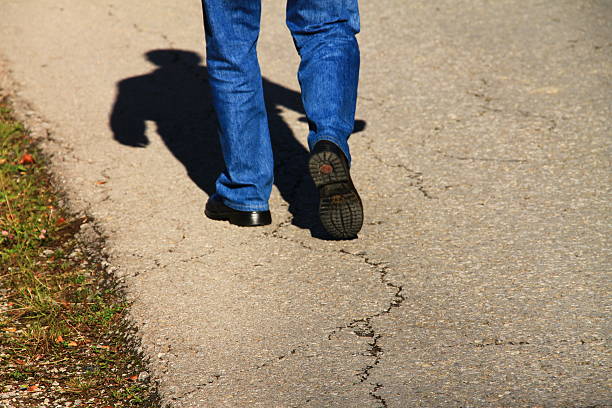 Old man slowly walking on the road