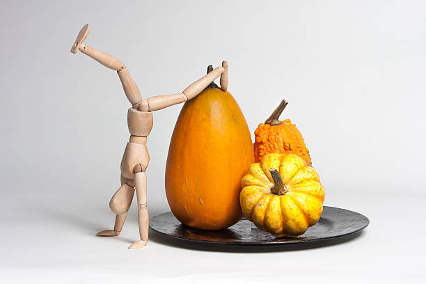 istock Pumpkins on a scale with a wooden doll. 521110421