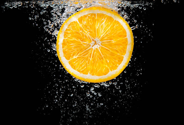 istock close-up orange slice in water with bubbles 521110873
