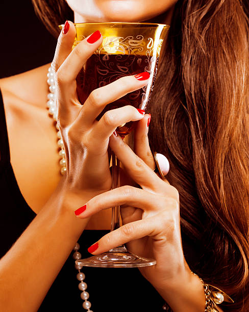 istock red manicure on fingers holding glass with vine 521111201