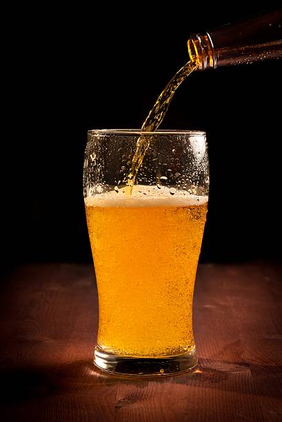 istock fresh beer pouring from bottle into glass 521126122