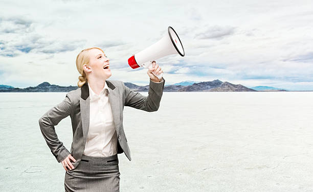 istock Smiling businesswoman shouting with bullhorn 521126872