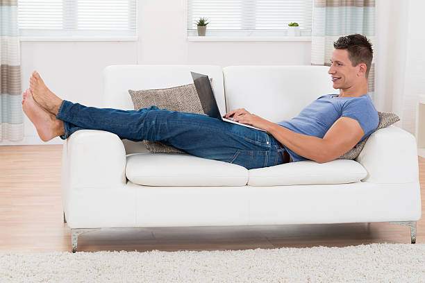 istock Man Using Laptop In Living Room 521127840