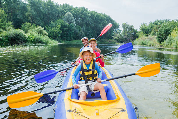 Family kayaking on the river Active happy family. Boy with his sister and father having fun together enjoying adventurous experience kayaking on the river on a sunny day during summer vacation kayaking stock pictures, royalty-free photos & images