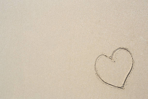 istock Heart drawn in the sand. Beach background. Top view 521132938