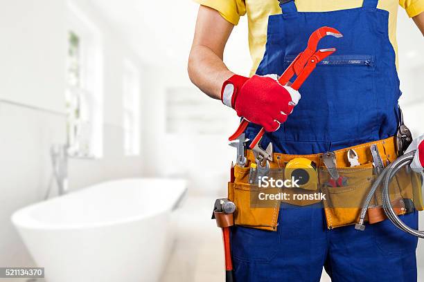 Foto de Encanador Com Cinto De Ferramentas De Pé No Banheiro e mais fotos de stock de Encanador