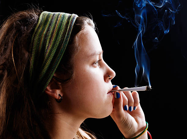 istock Defiant young hippie smokes her marijuana 521136759