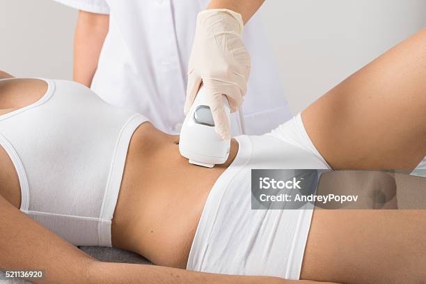 Woman Receiving Laser Treatment On Belly Stock Photo - Download Image Now - Medical Laser, Human Abdomen, Health Spa
